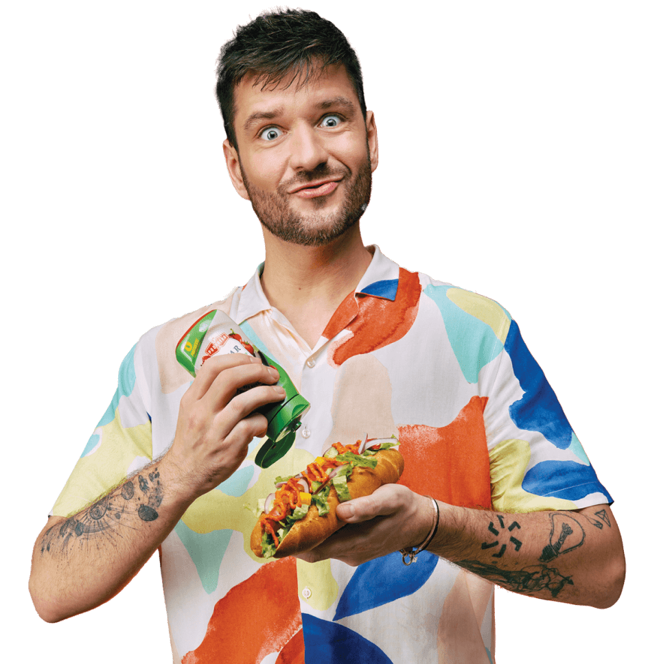 Muška osoba jede sendvič uz Ajvar